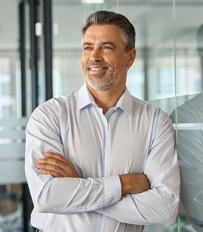 Happy man leaning with arms crossed